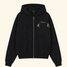 A black zip-up hoodie with a small embroidered graphic on the left chest depicting two figures and the text 'Friend', shown against a solid light beige background.