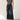Woman wearing a gray tank top and Noend dark blue wide-leg jeans against a white background