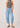 Person wearing a gray tank top and Noend light blue slung fit jeans on a white background