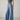 Person wearing a gray tank top and Noend blue wide-leg jeans on a plain background