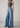 Person wearing a gray tank top and Noend blue wide-leg jeans on a plain background
