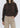 Person wearing a brown hoodie and beige pants on a white background